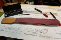 Installing Maple fret lines on the Purpleheart fingerboard.