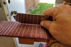Scraping the Maple fret lines flat to the fingerboard.