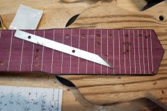 Drilling and cleaning holes for fingerboard dots.
