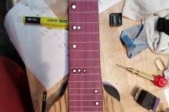 The Mother-Of-Pearl fingerboard dots are glued in.